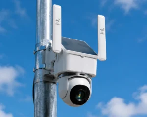 A solar-powered security camera with 4G antennas mounted on a metal pole under a clear blue sky, designed for outdoor surveillance.